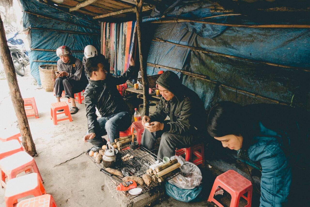 Người ngồi trên ghế ăn thức ăn đường phố Việt Nam ở Sapa